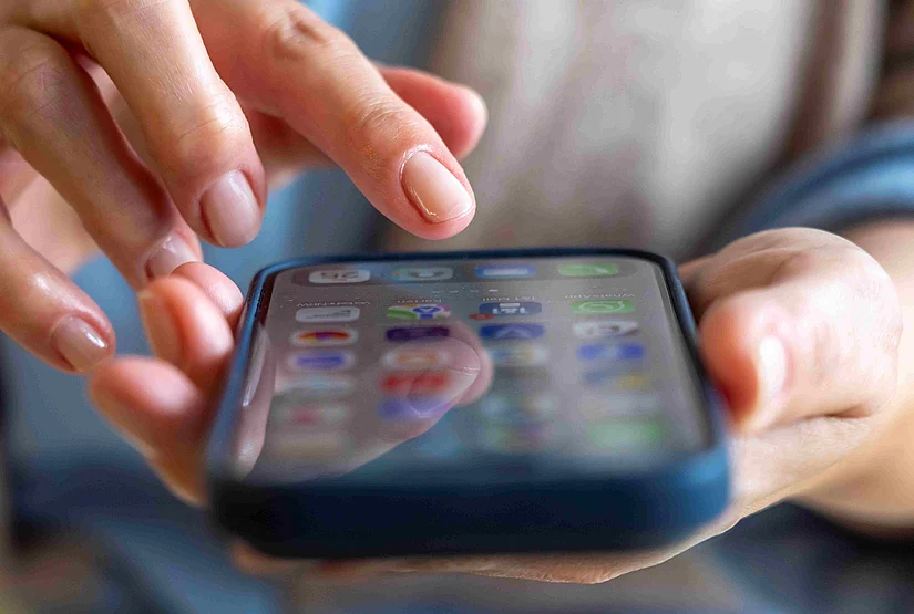 Handy, Mobiltelefon, in der Hand einer Nutzerin, Bildschirm mit verschiedenen Apps