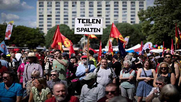 Demonstrators with poster Divide instead of columns Teilen Statt Spalten at the demonstration by international unions, left-wing initiatives and the DGB trade union association on May 1st, 2024 and Labor Day for fair wages, solidarity and fair working conditions under the slogan May 1st Make yourself strong with us in Berlin Germany 