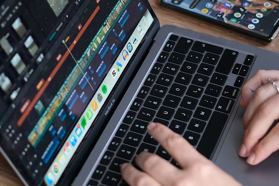 close up of a laptop screen and a pair of hands working on the laptop