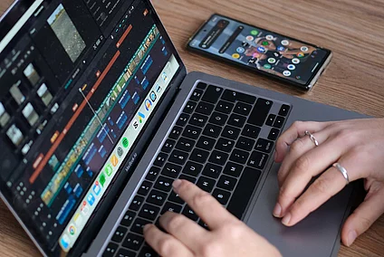 close up of a laptop screen and a pair of hands working on the laptop