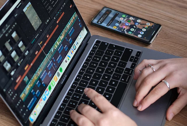 close up of a laptop screen and a pair of hands working on the laptop