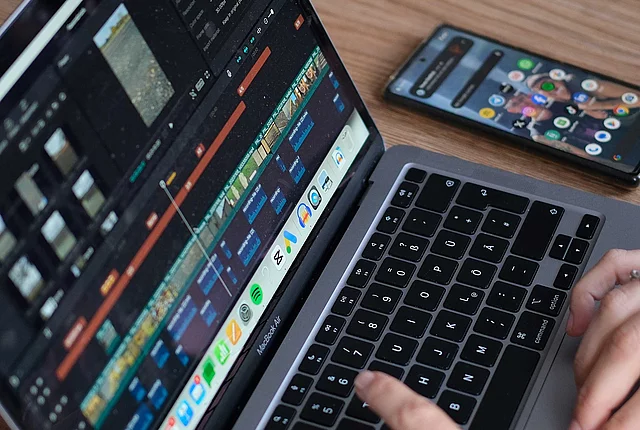 close up of a laptop screen and a pair of hands working on the laptop